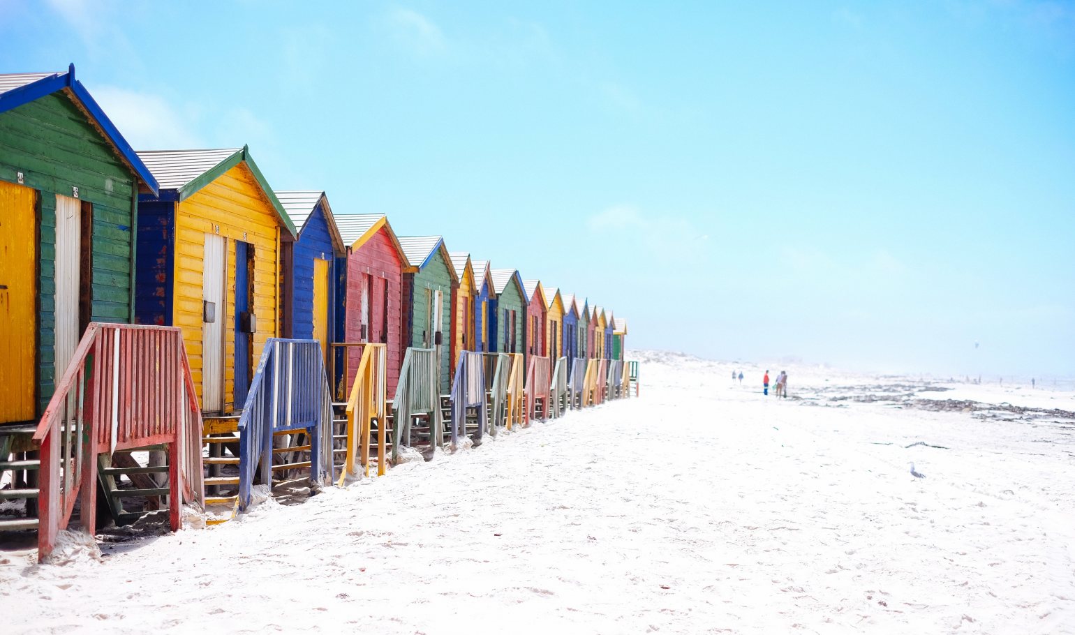 Colourful beach huts on a white sandy beach